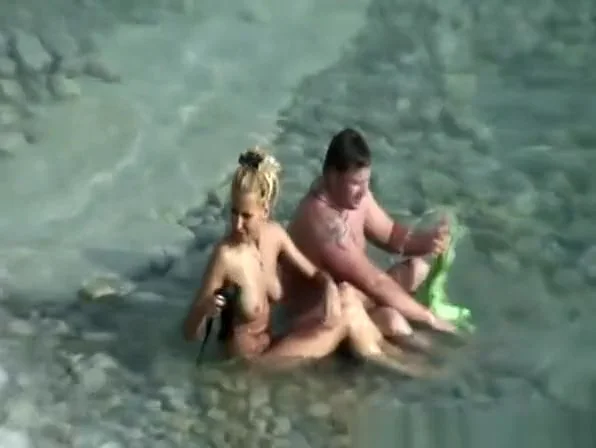 Nudist couple refreshing in water