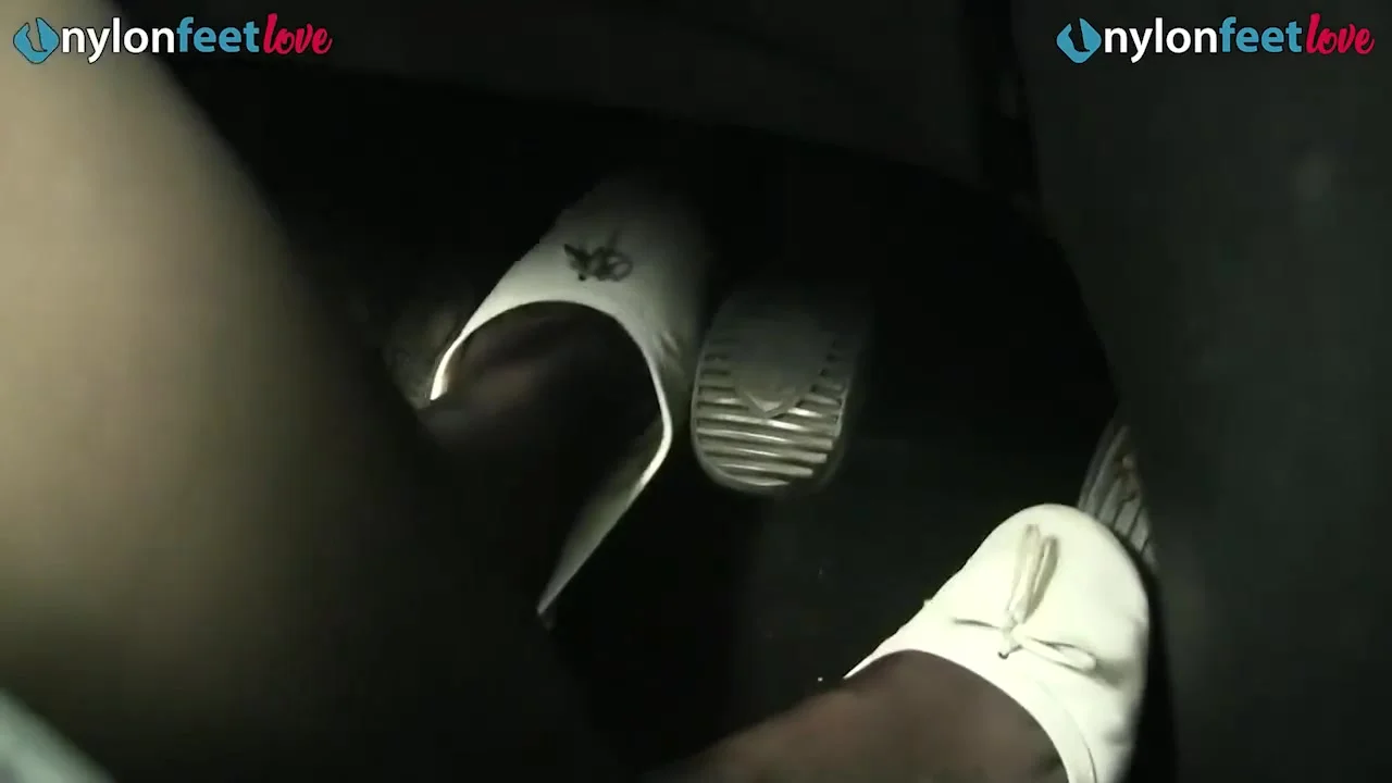 Redhead drives a car, shows upskirt and feet in stockings
